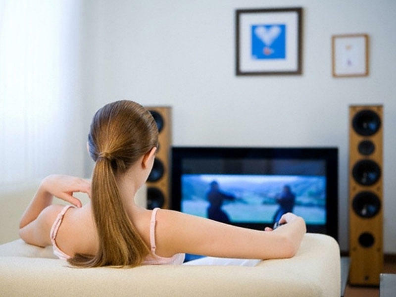 She s watching tv. Женщина у телевизора. Девушка перед телевизором. Девушка смотрит телевизор. Девушка смотрит ТВ.